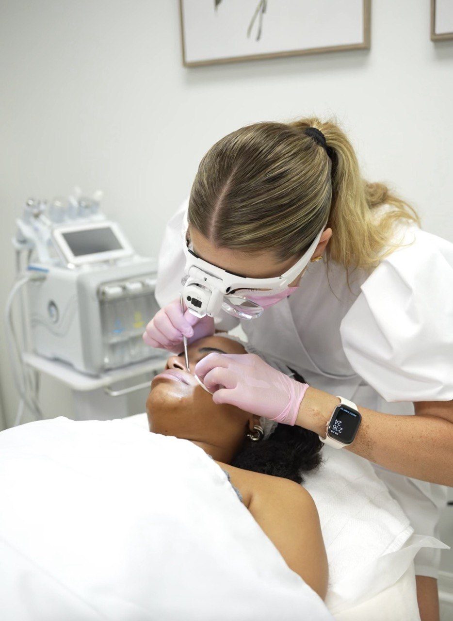 Tatiana doing extractions under a magnifying headlamp