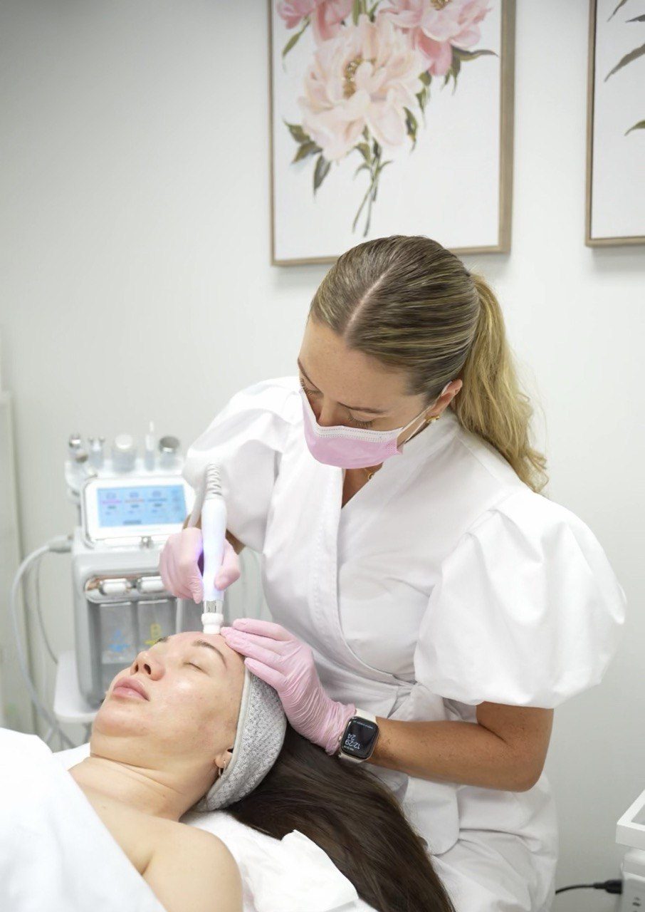 Tatiana using the hydro-dermabrasion handpiece, with the device behind her