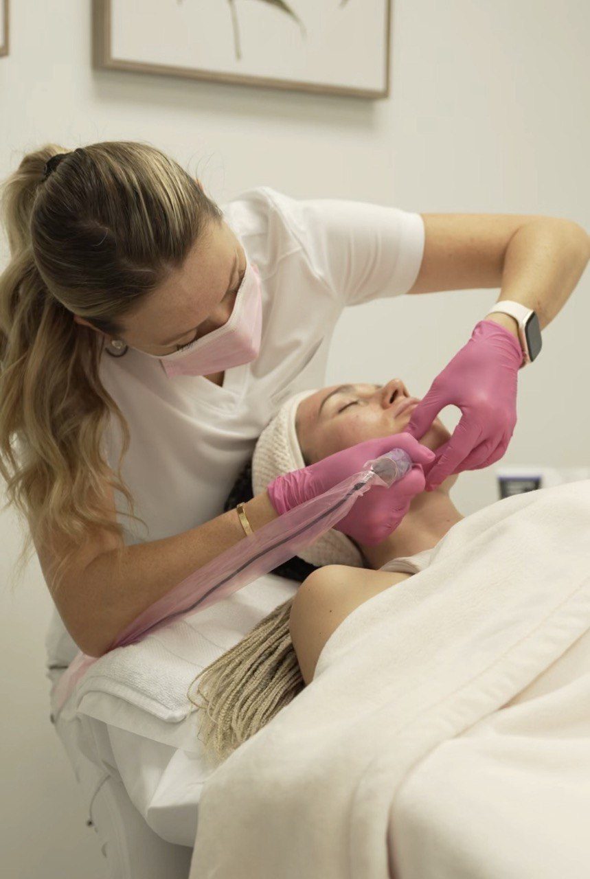 Tatiana working on a client's cheek with a microneedling pen