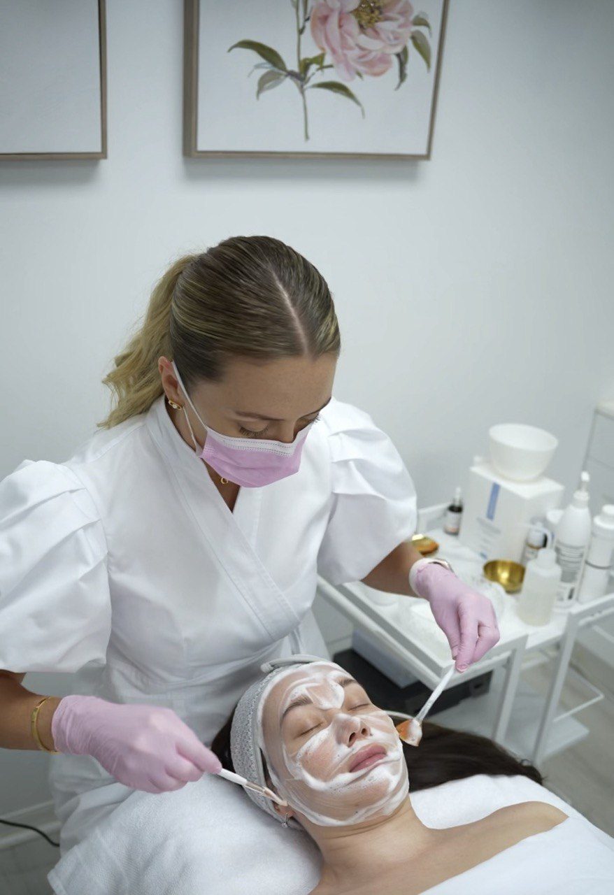 Tatiana brushing a peel onto a client's face